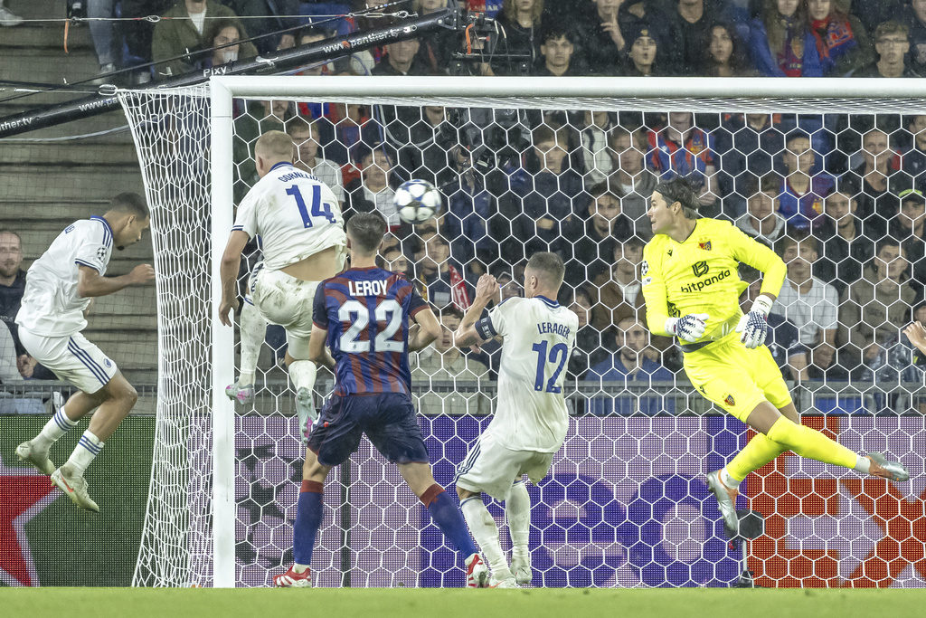 Copenhagen's Gabriel Pereira, left, scores a goal past Basel's goalkeeper Marwin Hitz, right, during the UEFA Champions League playoff first leg match between Switzerland's FC Basel 1893 and Denmark's F.C. Copenhagen at the St. Jakob-Park stadium in Basel, Switzerland, on Wednesday, Aug. 20, 2025. (Georgios Kefalas/Keystone via AP)