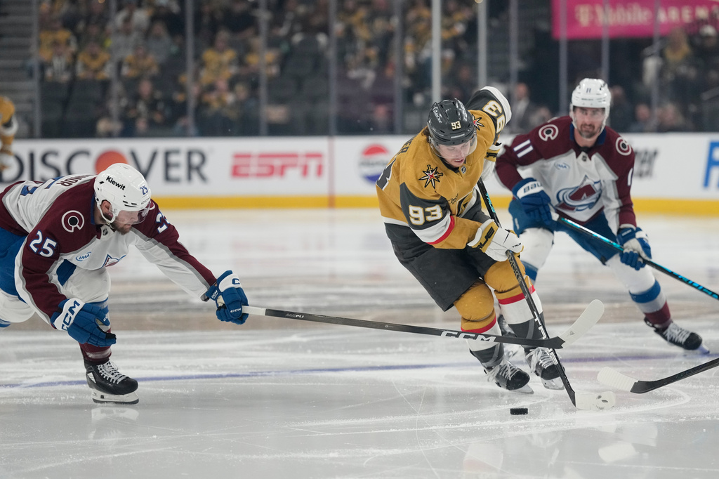Vegas Golden Knights right wing Mitch Marner (93) skates with the puck as Colorado Avalanche right wing Logan O'Connor (25) defends during the second period in Game 4 of the Western Conference finals NHL hockey Stanley Cup playoff series Tuesday, May 26, 2026, in Las Vegas. (AP Photo/John Locher)