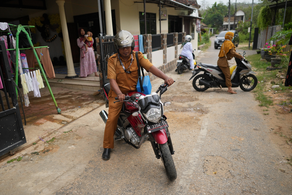 From left, health workers Indra Kurniawan, Fera Purnamasari and Siti Nurjanah ride their motorbikes during a house-to-house measles vaccination campaign following an outbreak in Sumenep on Madura Island, Indonesia, Monday, Sept. 8, 2025. (AP Photo/Dita Alangkara)