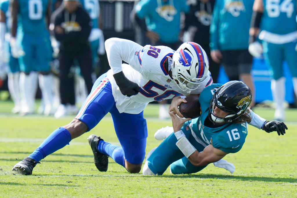Jacksonville Jaguars quarterback Trevor Lawrence (16) is sacked by Buffalo Bills defensive end Greg Rousseau (50) during the first half of an NFL wild-card playoff football game Sunday, Jan. 11, 2026, in Jacksonville, Fla. (AP Photo/Chris O'Meara)