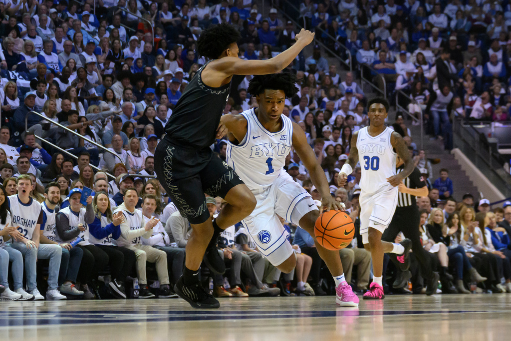 BYU guard Robert Wright III (1) drives to the basket guarded by Colorado guard Isaiah Johnson, left, during the first half of an NCAA college basketball game, Saturday, Feb. 14, 2026, in Provo, Utah. (AP Photo/Tyler Tate)