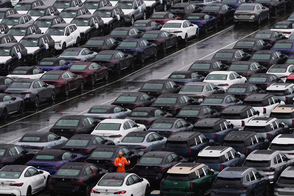 FILE - A worker checks on new cars parked in a lot at the International Car Operators terminal in the Port of Zeebrugge, Belgium, July 31, 2025. (AP Photo/Virginia Mayo, File)