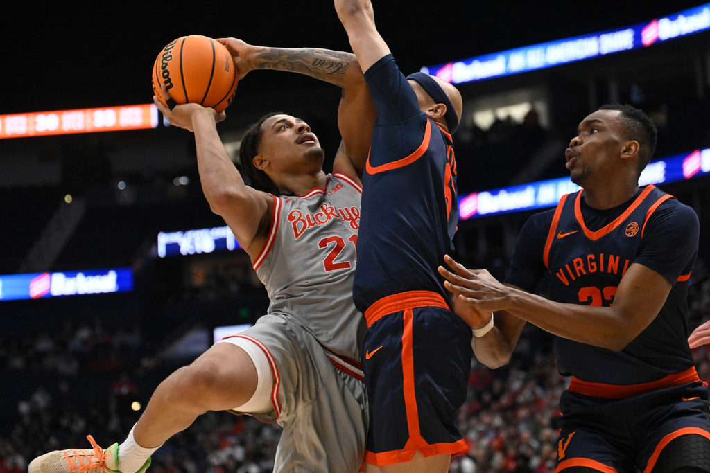 Ohio State forward Devin Royal (21) looks to shoot as Virginia guard Jacari White, center, and center Ugonna Onyenso, right, defend during the first half of an NCAA college basketball game Saturday, Feb. 14, 2026, in Nashville, Tenn. (AP Photo/John Amis)