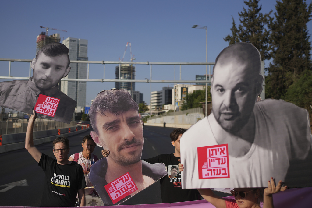 Demonstrators block a road during a protest demanding the immediate release of hostages held by Hamas and calling for the Israeli government to reverse its decision to take over Gaza City and other areas in the Gaza Strip, in Tel Aviv, Israel, Tuesday, Aug. 19, 2025. (AP Photo/Ohad Zwigenberg)