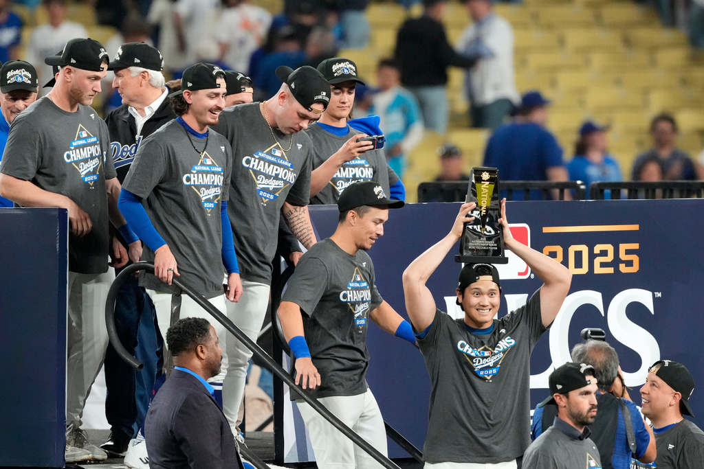 Los Angeles Dodgers' Shohei Ohtani celebrates the the trophy after their win against the Milwaukee Brewers in baseball's National League Championship Series, Friday, Oct. 17, 2025, in Los Angeles. (AP Photo/Mark J. Terrill)