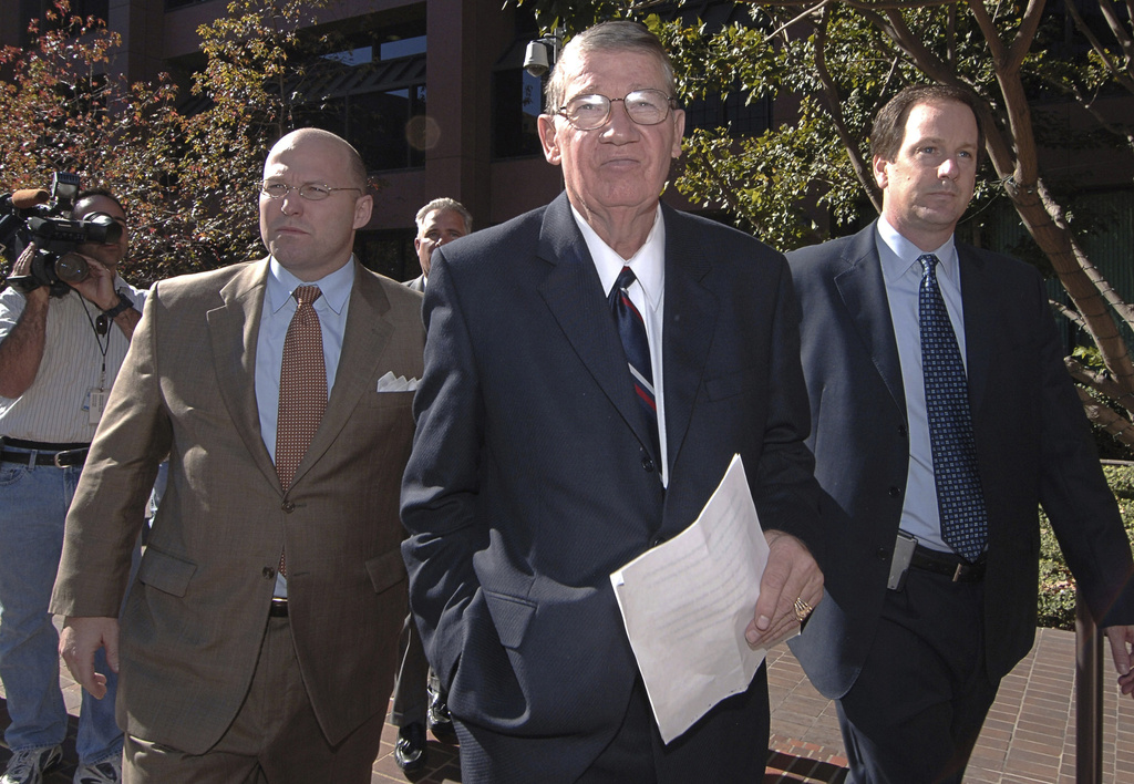 FILE - Republican Rep. Randy "Duke" Cunningham, center, of California, is escorted by his attorney, Mark Holscher, right, from the federal courthouse in San Diego, Nov. 28, 2005, after pleading guilty to bribery. (AP Photo/Denis Poroy, File)