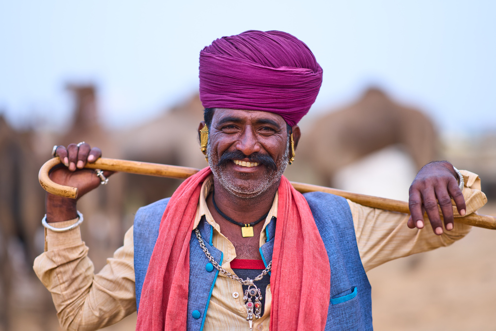 A camel herder poses for a photograph at the annual cattle fair in Pushkar, in the western Indian state of Rajasthan, Sunday, Oct. 26, 2025. (AP Photo/Rajesh Kumar Singh)
