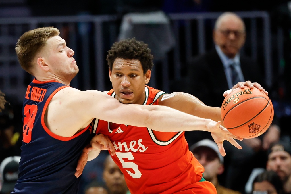 Miami forward Malik Reneau (5) moves the ball against Virginia forward Thijs de Ridder, left, during the first half of an NCAA college basketball game in the semifinals of the Atlantic Coast Conference tournament in Charlotte, N.C., Friday, March 13, 2026. (AP Photo/Nell Redmond)