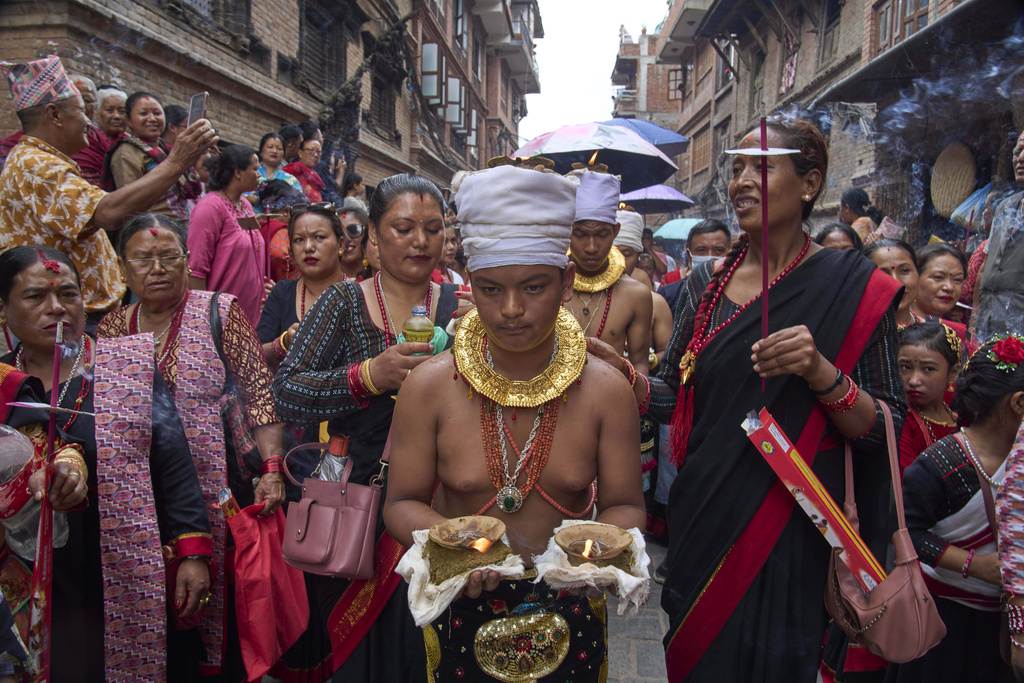 Devotees light oil lamps on their head during a parade celebrating the birthday of Lord Krishna on Krishna Janmashtami in Bhaktapur,Nepal, Saturday, Aug. 16, 2025. (AP Photo/Niranjan Shrestha)