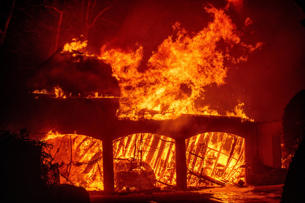 FILE - The Eaton Fire burns a residence Wednesday, Jan. 8, 2025 in Altadena, Calif. (AP Photo/Ethan Swope, File)