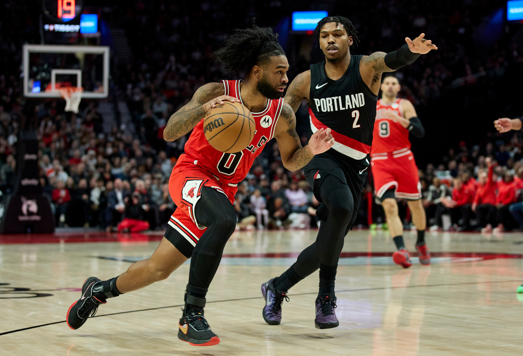 Chicago Bulls guard Coby White, left, dribbles past Portland Trail Blazers guard Caleb Love during the second half of an NBA basketball game in Portland, Ore., Wednesday, Nov. 19, 2025. (AP Photo/Craig Mitchelldyer)