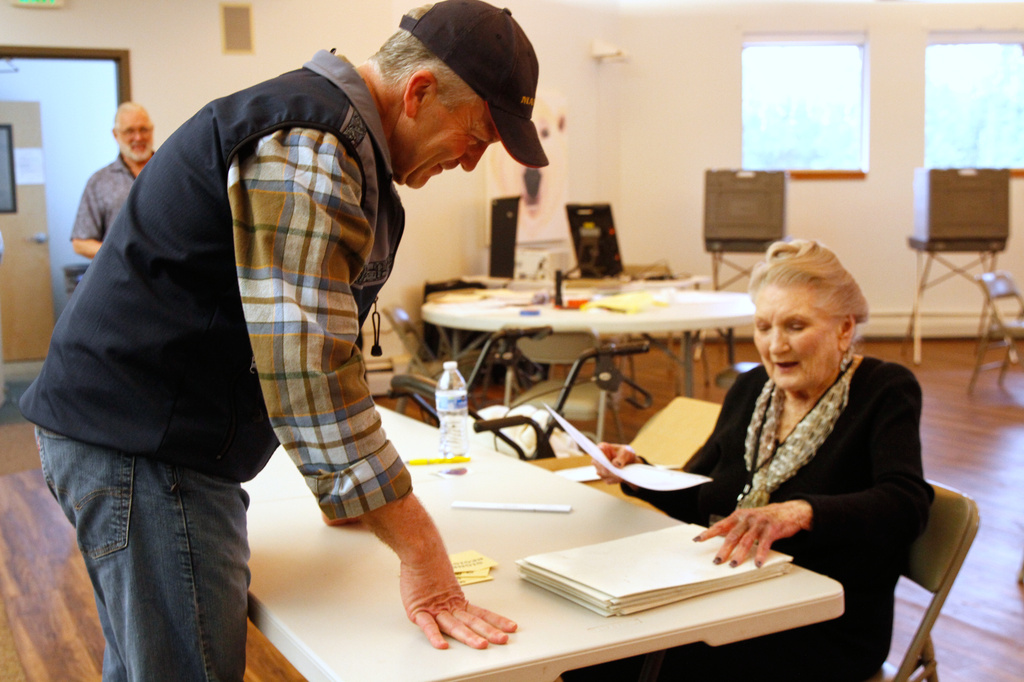 Sen. Dan Sullivan, R-Alaska, receives his ballot from poll worker Jo Ann Johnson to vote in the primary election, at his precinct located at the Alaska Zoo in Anchorage, Alaska., Tuesday, Aug. 18, 2026. (AP Photo/Mark Thiessen)