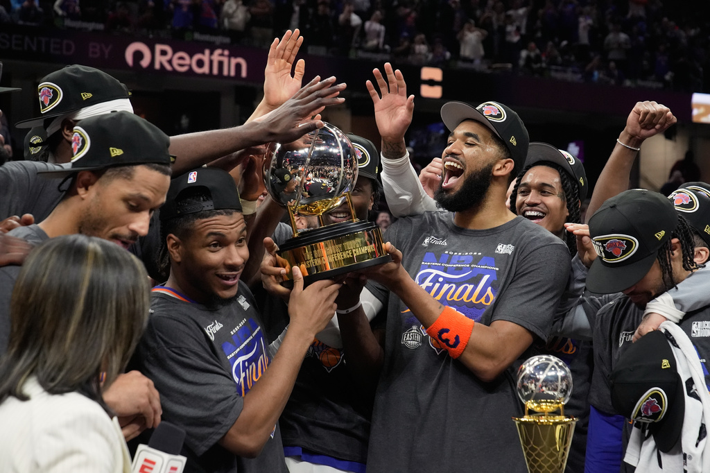 The New York Knicks hold the Eastern Conference Championship trophy after Game 4 in the Eastern Conference finals NBA basketball playoffs series against the Cleveland Cavaliers in Cleveland, Monday, May 25, 2026. (AP Photo/Sue Ogrocki)