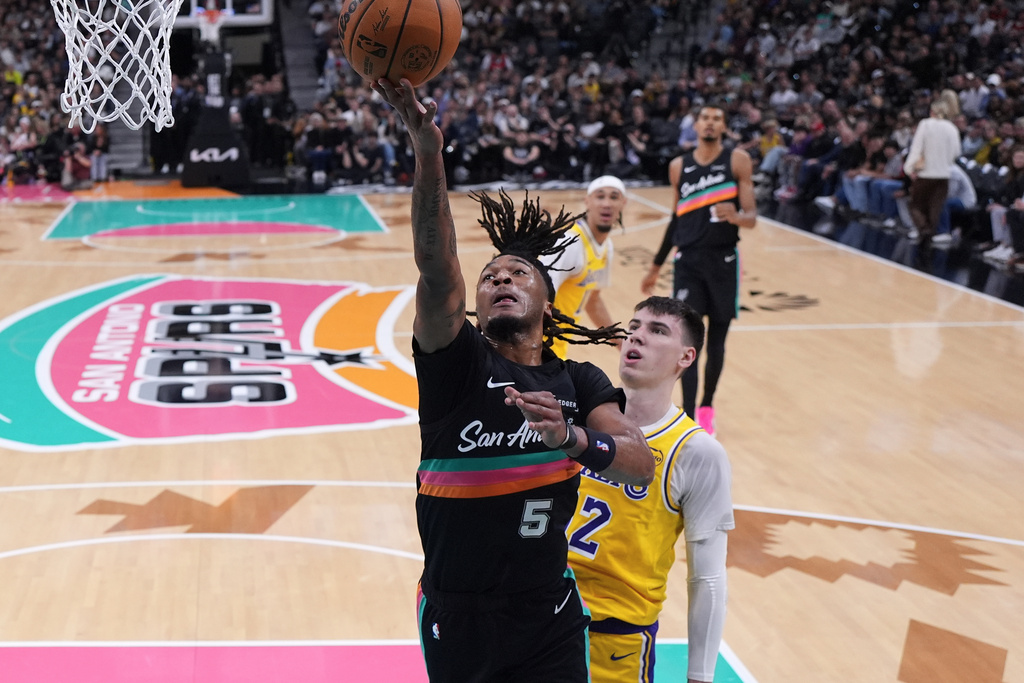San Antonio Spurs guard Stephon Castle (5) scores past Los Angeles Lakers forward Jake Laravia (12) during the first half of an NBA basketball game in San Antonio, Wednesday, Jan. 7, 2026. (AP Photo/Eric Gay)