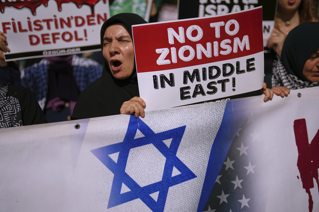 FILE - People shout slogans during an anti Israel protest in Istanbul, Turkey, Saturday, June 21, 2025. The board on the left reads, in Turkish: "Get out of Palestine". (AP Photo/Francisco Seco, File)