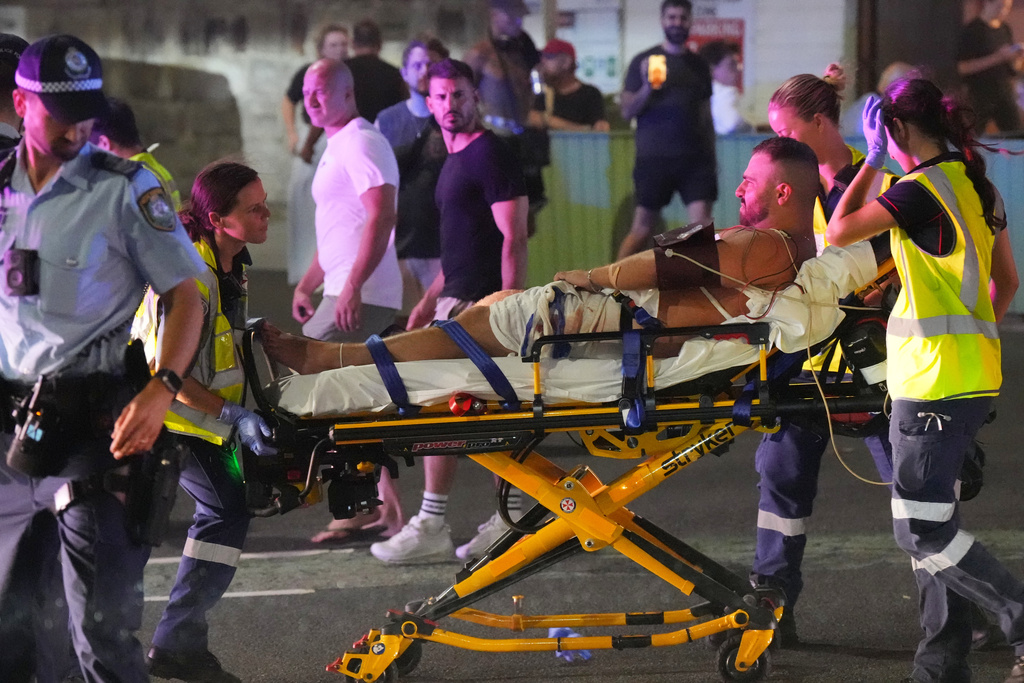 Emergency workers transport a person on a stretcher after a reported shooting at Bondi Beach in Sydney, Sunday, Dec. 14, 2025. (AP Photo/Mark Baker)