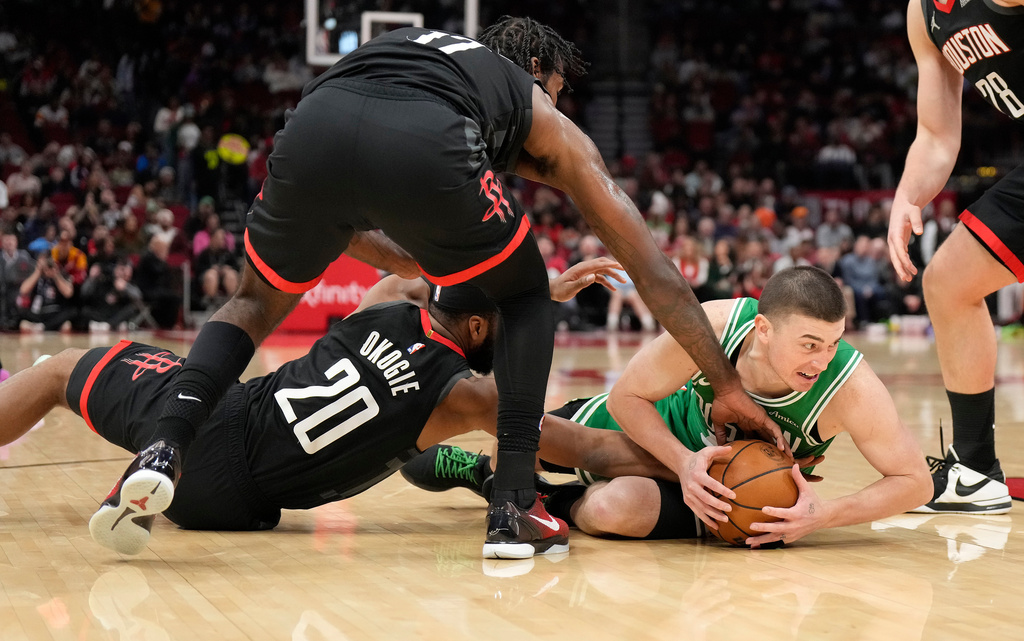 Boston Celtics guard Payton Pritchard (11) tries to get control of the ball against Houston Rockets' Tari Eason (17), and Josh Okogie (20) during the first half of an NBA basketball game, in Houston, Wednesday, Feb. 4, 2026. (AP Photo/ Karen Warren)