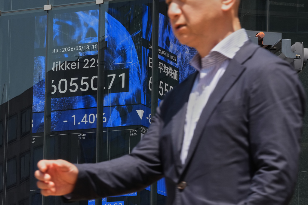 A person walks in front of an electronic board at a business building showing Japan's Nikkei index, Monday, May 18, 2026, in Tokyo. (AP Photo/Eugene Hoshiko)