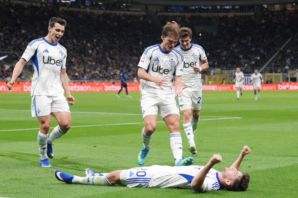 Como's Martin Baturina, on ground, celebrates after scoring his side's opening goal during the Italian Cup, return-leg soccer match between Inter Milan and Como, in Milan, Italy, Tuesday, April 21, 2026. (Spada/LaPresse via AP)