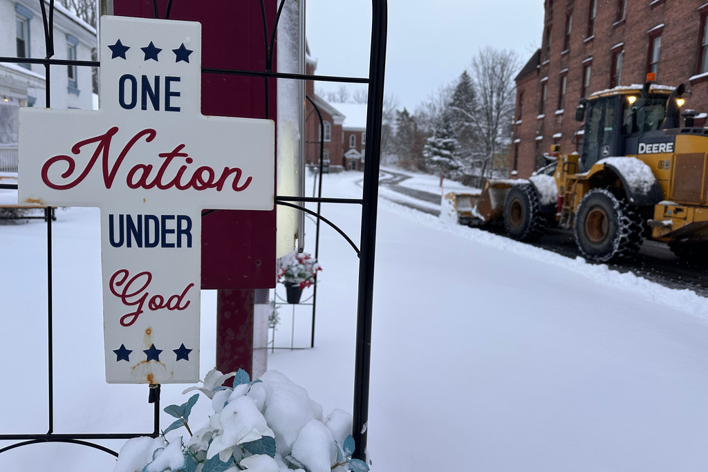 A snowplow operates outside a church in Lowville, N.Y., on Friday, Nov. 28, 2025. (AP Photo/Cara Anna)