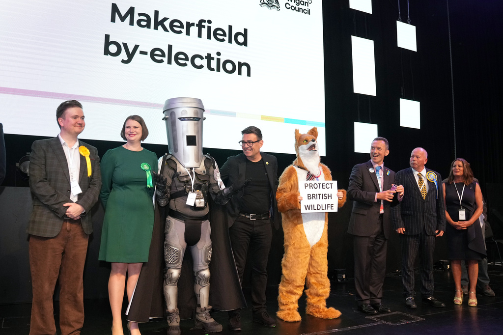 Labour party candidate Andy Burnham, center, stands with other candidates on the podium at the Edge Wigan, awaiting the Makerfield by-election result announcement in Wigan, England, Friday, June 19, 2026.(AP Photo/Jon Super)