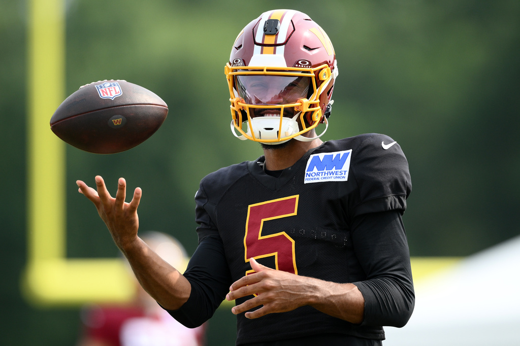 Washington Commanders quarterback Jayden Daniels works out before a joint practice with the Miami Dolphins at NFL football training camp, Wednesday, Aug. 12, 2026 in Ashburn, Va. (AP Photo/Nick Wass)