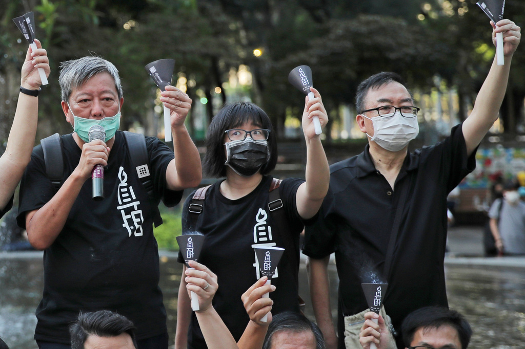 FILE - Fom left, pro-democracy activists Lee Cheuk-yan, Chow Hang-tung, and Cheung Man-kwong attend a gathering to mourn for those killed in the 1989 Tiananmen crackdown at Victoria Park, in Hong Kong on June 4, 2020. (AP Photo/Kin Cheung, File)