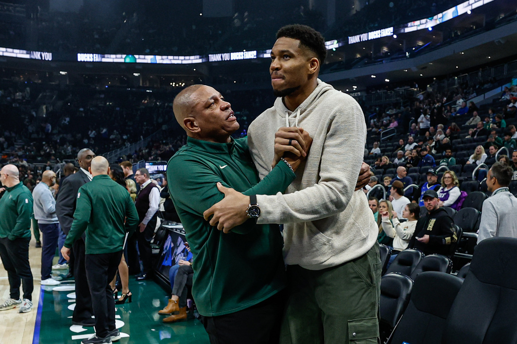 Milwaukee Bucks head coach Doc Rivers, center left, and Giannis Antetokounmpo, center right, embrace before an NBA basketball game against the Brooklyn Nets, Friday, April 10, 2026, in Milwaukee. (AP Photo/Jeffrey Phelps)