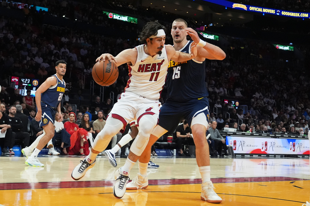 Miami Heat forward Jaime Jaquez Jr. (11) drives to the basket as Denver Nuggets center Nikola Jokic (15) defends during the first half of an NBA basketball game, Monday, Dec. 29, 2025, in Miami. (AP Photo/Lynne Sladky)