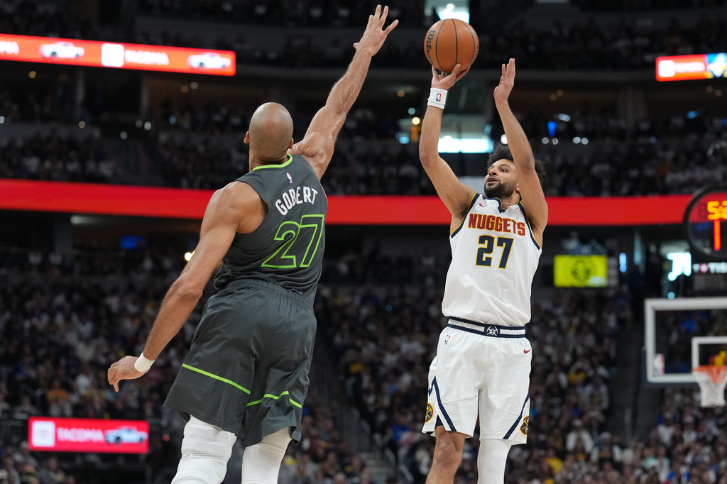 Denver Nuggets guard Jamal Murray, right, shoots over Minnesota Timberwolves center Rudy Gobert in the first half in Game 1 of a first-round NBA playoffs basketball series, Saturday, April 18, 2026, in Denver. (AP Photo/David Zalubowski)