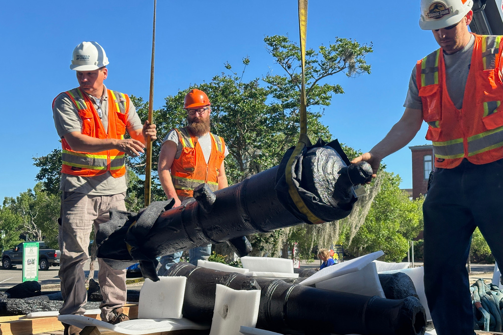 Terry Koller, Bradford Shields and Joseph Robinson steady a cannon, which sunk to the bottom of the Savannah River during the American Revolution, as it's hoisted from the bed of a truck at the Savannah History Museum in Savannah, Ga., on Wednesday, June 3, 2026. (AP Photo/Russ Bynum)