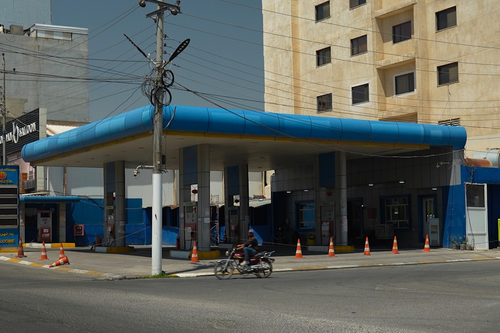 A motorcycle driver passes a gas station during a fuel shortage in Irbil, Iraq, Tuesday, July 28, 2026. (AP Photo/Stella Martany)