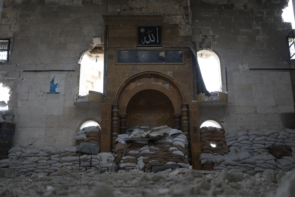 Sandbag barriers used as fighting positions by Kurdish fighters, left inside a destroyed mosque in the Sheikh Maqsoud neighborhood, where clashes between government forces and Kurdish fighters have been taking place in the northern city of Aleppo, Syria, Sunday, Jan. 11, 2026. (AP Photo/Ghaith Alsayed)