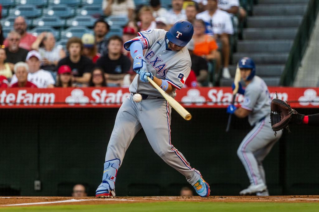 Texas Rangers designated hitter Joc Pederson (3) hits a homer during the first inning of a baseball game against the Los Angeles Angels, Tuesday, Aug. 11, 2026, in Anaheim, Calif. (AP Photo/Ethan Swope)