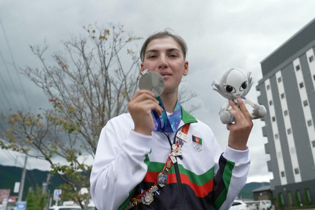 In this image made from video, Afghanistan's Fariba Hashim displays the silver medal she won for Women's Road Race, in Shinshiro, Japan, Wednesday, Sept. 23, 2026. (SNTV via AP)