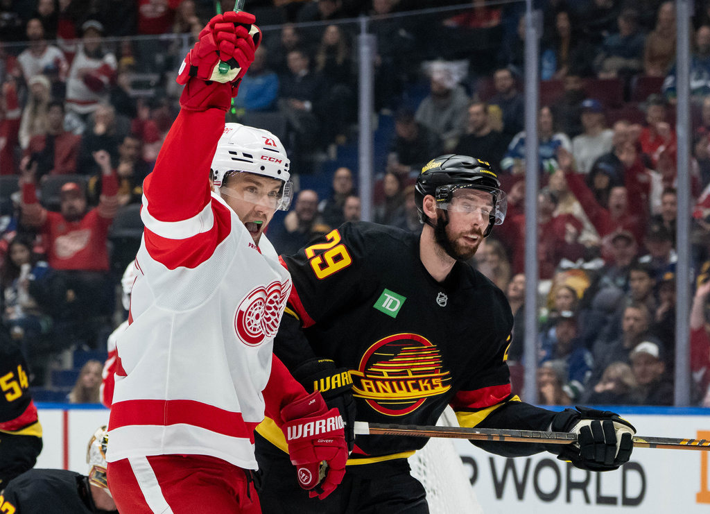 Detroit Red Wings' James van Riemsdyk (21) celebrates his goal as Vancouver Canucks' Marcus Pettersson (29) skates away during first period NHL hockey action in Vancouver, B.C., Monday, Dec. 8, 2025. (Ethan Cairns/The Canadian Press via AP)