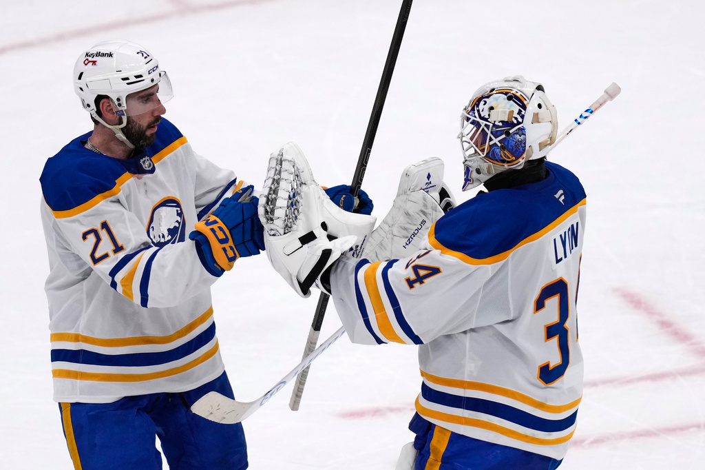 Buffalo Sabres goaltender Alex Lyon (34) is congratulated by Conor Timmins (21) after defeating the Boston Bruins in Game 3 of a first-round NHL hockey Stanley Cup playoff series, Thursday, April 23, 2026, in Boston. (AP Photo/Charles Krupa)