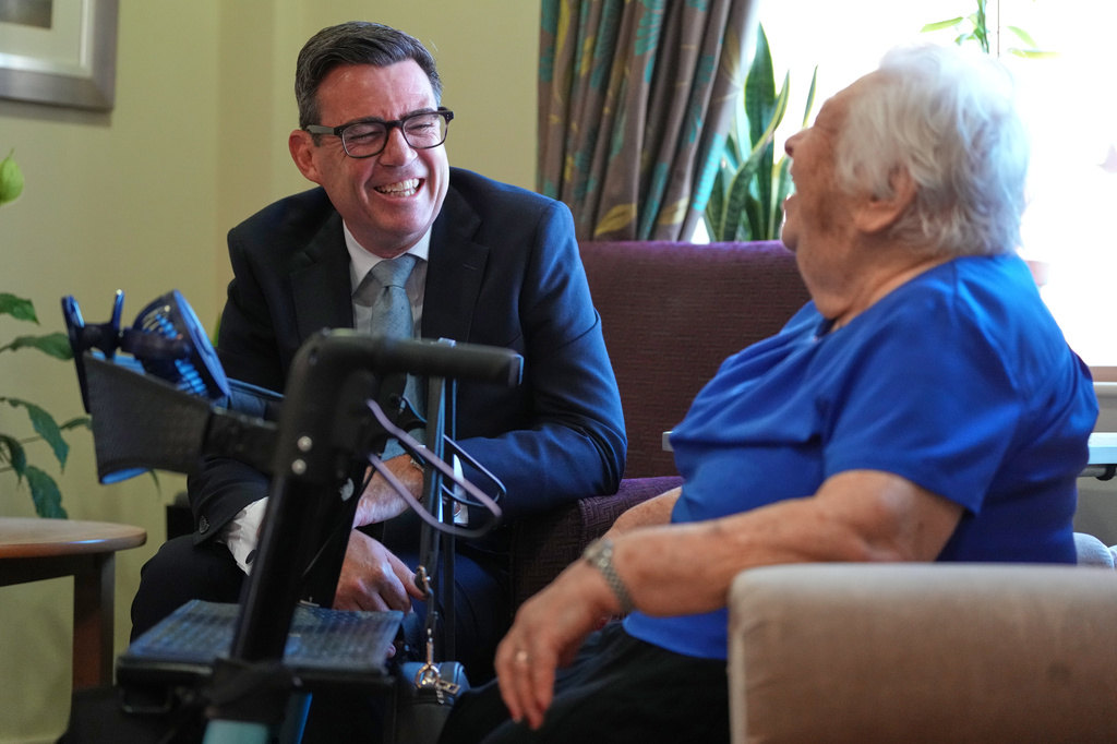 Britain's Prime Minister Andy Burnham talks to a resident during a visit to a care home in London, Wednesday, July 29, 2026.(AP Photo/Kirsty Wigglesworth, Pool)