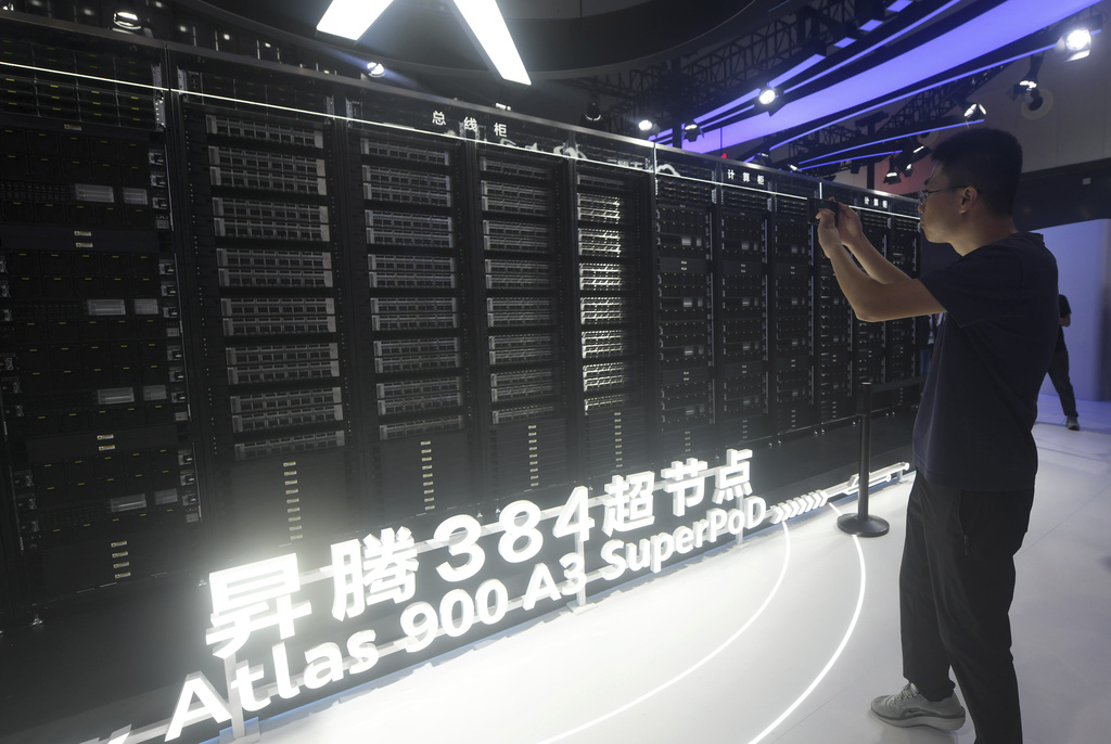 A visitor takes photos of the Huawei Atlas 900 A3 SuperPoD exhibited at the World Artificial Intelligence Conference in Shanghai, China, July 26, 2025. (Chinatopix Via AP) CHINA OUT