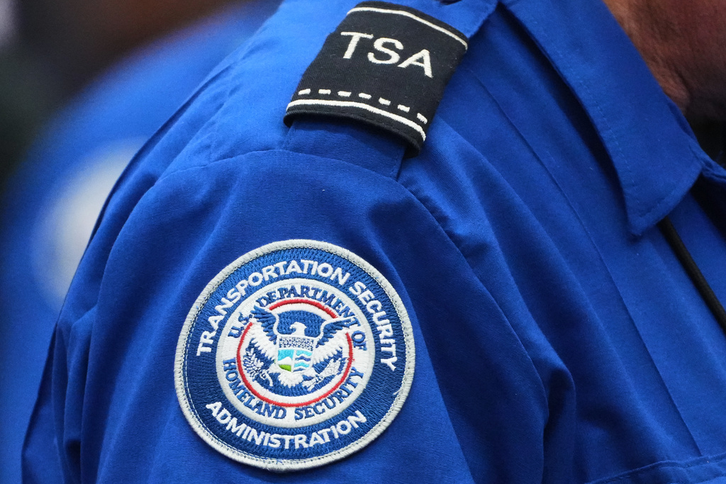 A TSA agent wears a Transportation Security Administration badge while checking identification at Seattle-Tacoma International Airport, Thursday, Nov. 6, 2025, in SeaTac, Wash. (AP Photo/Lindsey Wasson)