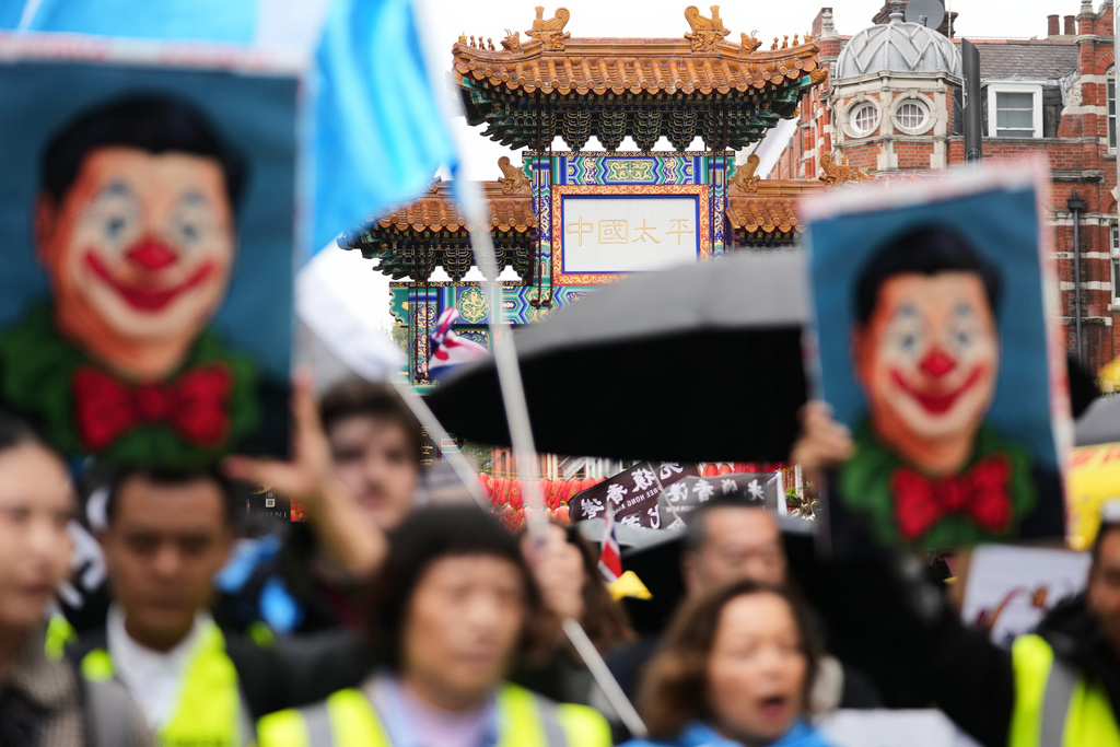 FILE -Protesters hold umbrellas, placards, and flags as they demonstrate against the proposed building of a new Chinese embassy, and to mark the 11th year of the Umbrella Revolution in Hong Kong, in London, Sept. 28, 2025. (AP Photo/Joanna Chan, File)