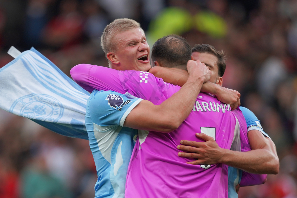 Manchester City's Erling Haaland, left, Manchester City's goalkeeper Gianluigi Donnarumma, Manchester City's Ruben Dias celebrate after the English Premier League soccer match between Manchester United and Manchester City in Manchester, England, Sunday, Sept. 13, 2026. (AP Photo/Ian Hodgson)