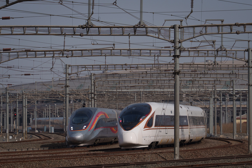 Two high-speed trains travel along parallel tracks in Beijing, China, Tuesday, Feb. 10, 2026. (AP Photo/Vincent Thian)