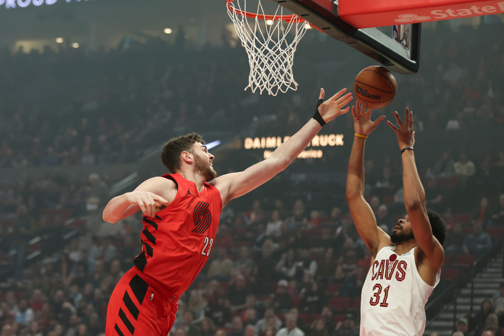 Portland Trail Blazers center Donovan Clingan (23) and Cleveland Cavaliers center Jarrett Allen (31) grab for a rebound during the first half of an NBA basketball game Sunday, Feb. 1, 2026, in Portland, Ore. (AP Photo/Amanda Loman)
