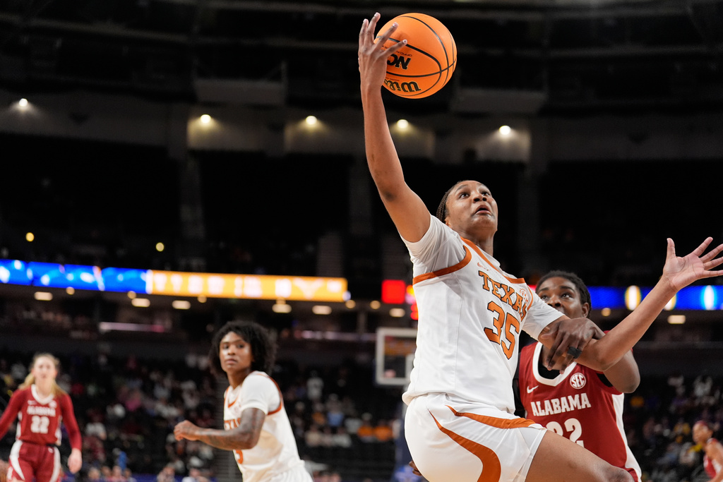 Texas forward Madison Booker vies for the ball with Alabama forward Alancia Ramsey during first half of an NCAA college basketball game in the quarterfinals of the Southeastern Conference tournament, Friday, March 6, 2026, in Greenville, S.C. (AP Photo/Chris Carlson)