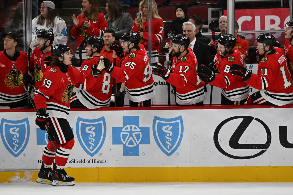 Chicago Blackhawks' Tyler Bertuzzi (59) celebrates with teammates at the bench after scoring during the first period of an NHL hockey game against the Vegas Golden Knights, Sunday, Jan. 4, 2026, in Chicago. (AP Photo/Paul Beaty)