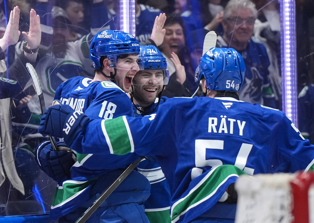 Vancouver Canucks' Drew O'Connor (18), Jake DeBrusk (74) and Aatu Raty (54) celebrate O'Connor's goal against the Anaheim Ducks during the third period of an NHL hockey game, in Vancouver, British Columbia, Thursday, Jan. 29, 2026. (Darryl Dyck/The Canadian Press via AP)
