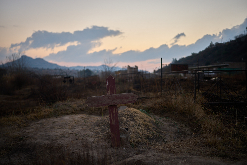 A cross is seen at a cemetery where hundreds of people who died of AIDS are buried in Maseru, Lesotho, July 20, 2025. (AP Photo/Bram Janssen)