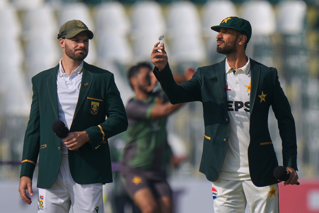 Pakistan's Shan Masood, right, flips the coin for toss as South Africa's Aiden Markram watches before the start of the play of second test cricket match between Pakistan and South Africa, at the Rawalpindi Cricket Stadium, in Rawalpindi, Pakistan, Monday, Oct. 20, 2025. (AP Photo/Anjum Naveed)