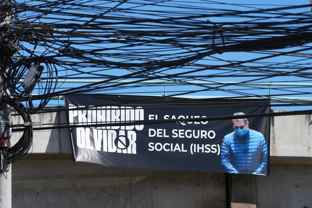 A banner with an image of former Honduran President Juan Orlando Hernandez with a message that reads in Spanish: "It is forbidden to forget the looting of social security" hangs on a bridge in Tegucigalpa, Honduras, Saturday, Nov. 29, 2025, a day after President Donald Trump said he plans to pardon Hernandez for a 2024 drug trafficking sentence. (AP Photo/Moises Castillo)